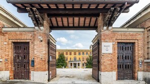 Entrada de un edificio con dos puertas grandes, un porche cubierto y un letrero que dice 'PALAZZO DEL TOLTE'.