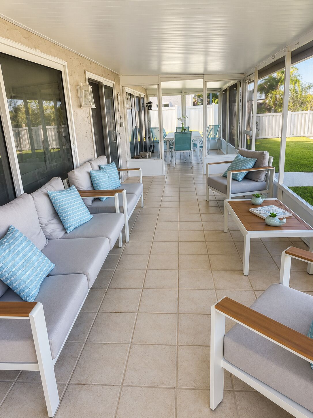 A covered patio area with a sofa set, a dining table, and chairs.