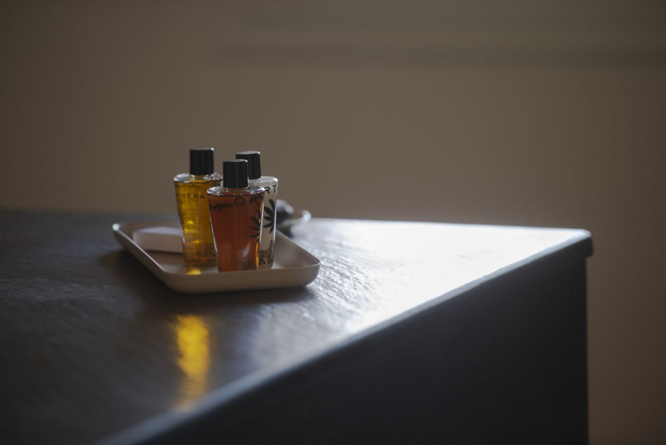 Una bandeja con tres frascos de perfume sobre una mesa.