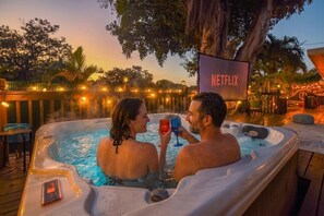 A couple in a hot tub with a Netflix sign in the background.