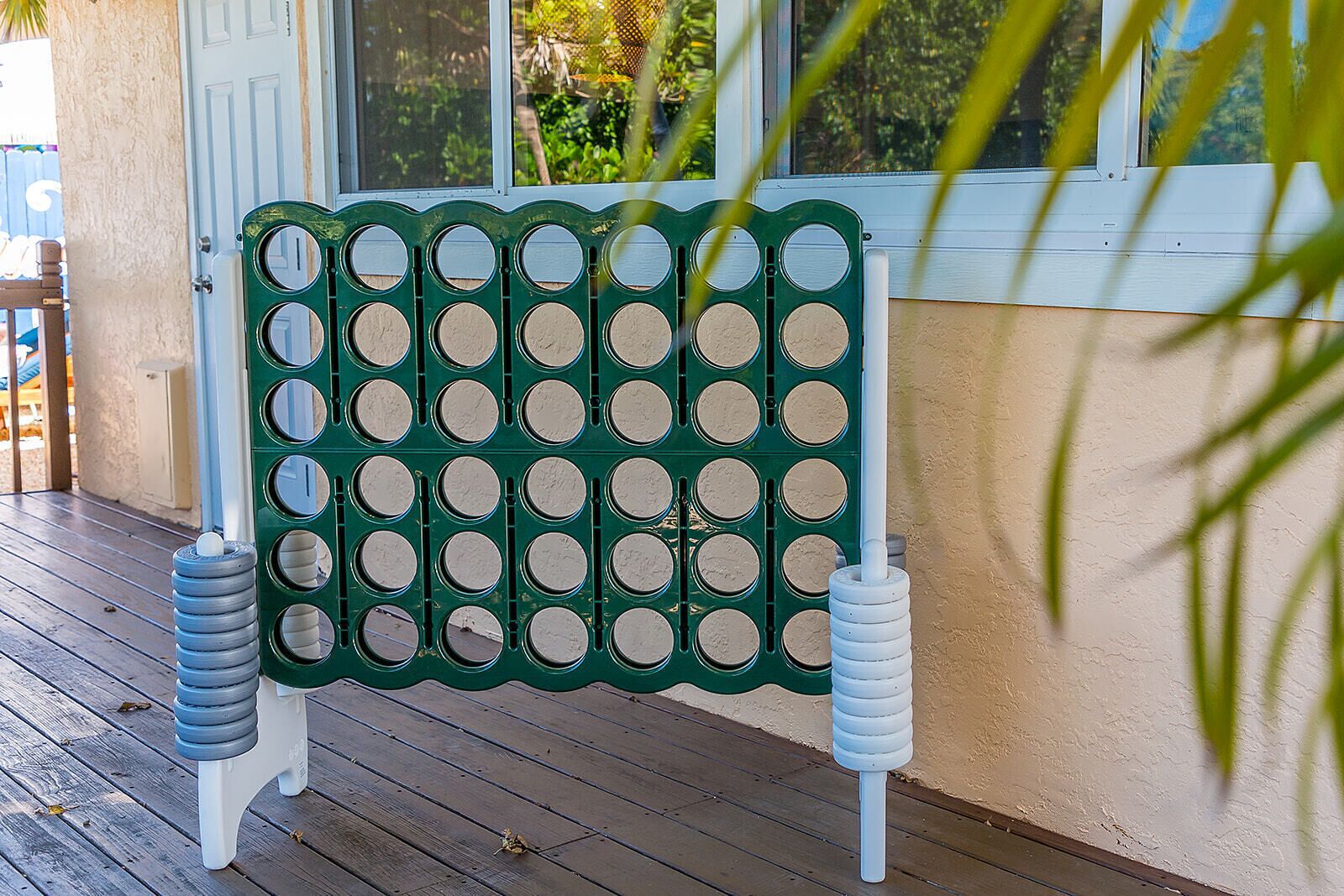 Un espacio al aire libre con asientos verdes y blancos, una banca y dos objetos cilíndricos a cada lado.