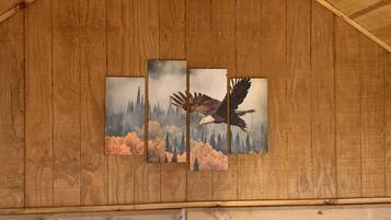 Una pared de madera con tres cuadros enmarcados de un águila volando.