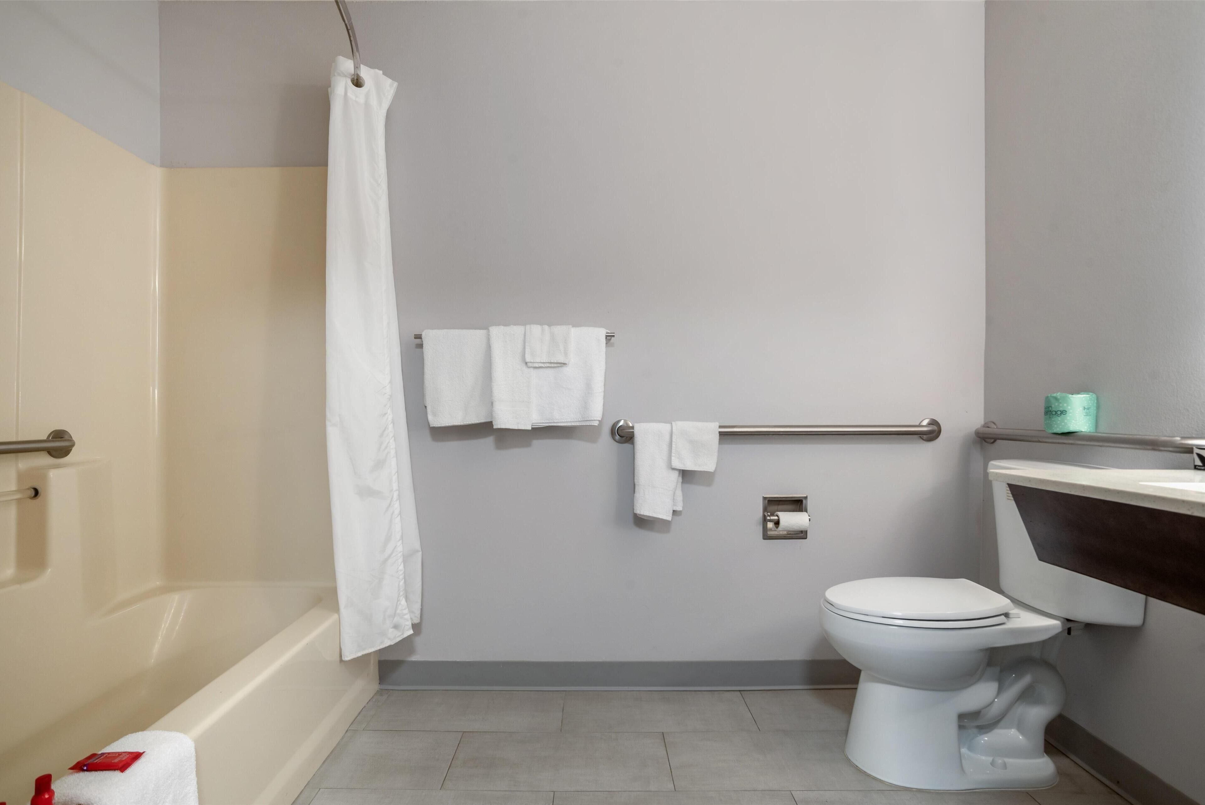 Ein Badezimmer mit Badewanne, Toilette und Handtuchhalter.