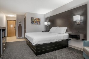 A modern hotel room with a large bed, a flat-screen TV, a desk, and a nightstand. - Surestay Plus By Best Western St. James Donaldsonville (St James)