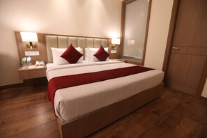 A hotel room with a large bed, wooden flooring, and two bedside tables with lamps. - Surestay By Best Western Lucknow (Lucknow)