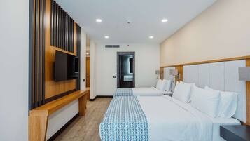 Una habitación de hotel moderna con dos camas, un televisor, un panel de pared de madera y un banco.