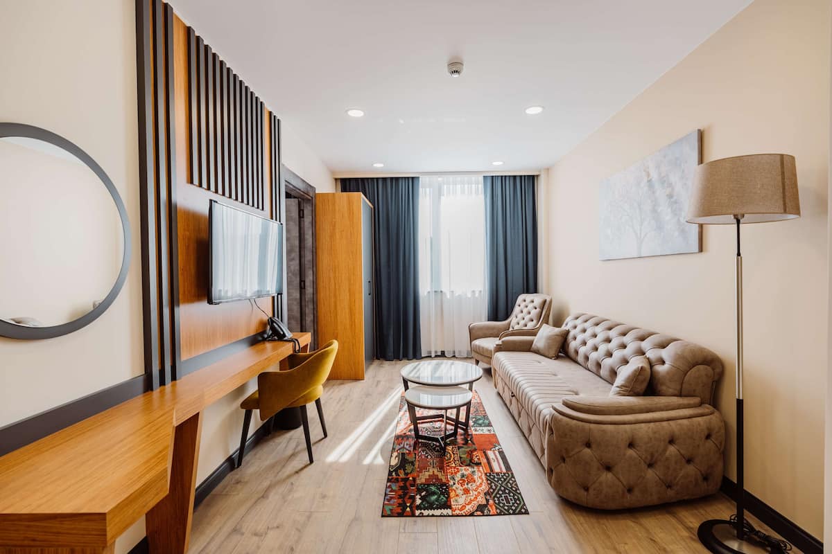A modern living room with a sofa, a coffee table, a TV, and a lamp.