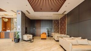 A modern lobby with a reception desk, seating area, and a large plant. - Best Western Plus Batumi (Batumi)