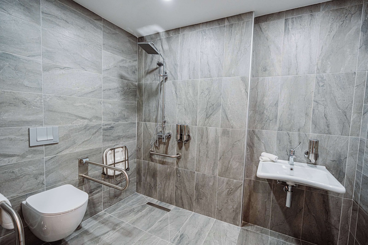 A modern bathroom with a shower, toilet, and sink.