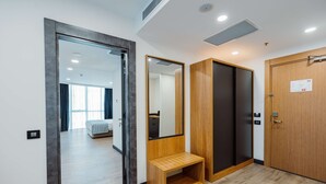 A hotel room with a wooden bench, a large mirror, a wardrobe, and a door with a lock. - Best Western Plus Batumi (Batumi)