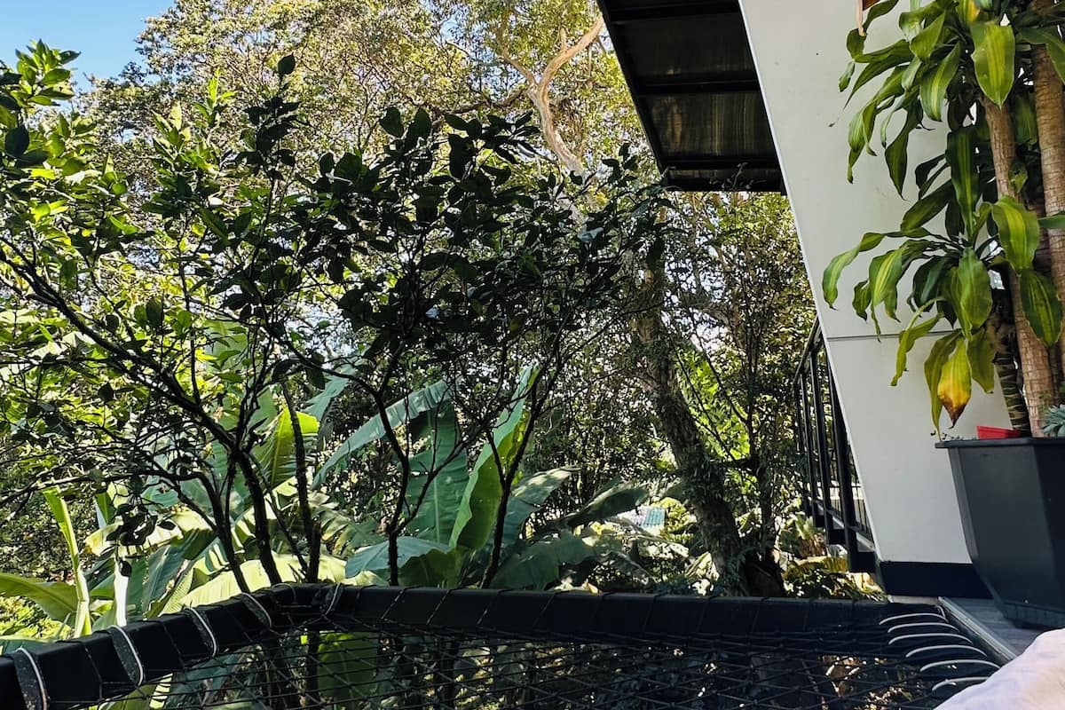 Una habitación con vistas a un jardín, una hamaca y una cama.