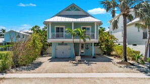 Una casa de dos pisos con un balcón, un garaje y un letrero que dice "The Jersey Girl".