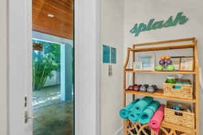 A reception area with a wooden shelf displaying yoga mats, dumbbells, and a QR code.