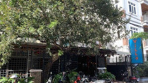 Un bâtiment sur lequel on peut lire l’inscription « Villa », avec une rangée de scooters garés devant.