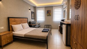 A modern bedroom with a bed, bedside table, wardrobe, and a small desk area.