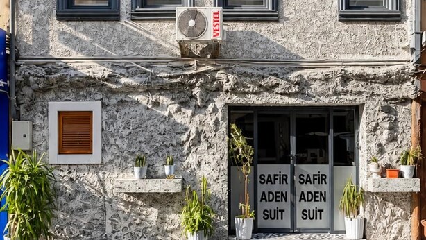 A multi-story building with air conditioning units and a sign indicating a business named 'VESTEL'.