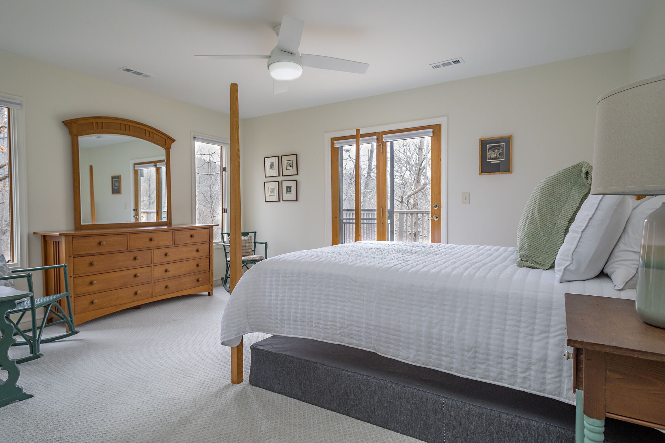 A bedroom with a bed, dresser, and a large mirror.