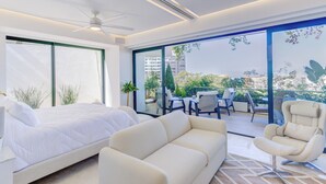 Una camera da letto moderna con un letto, una poltrona e una sedia. È presente un balcone con vista sulla città.