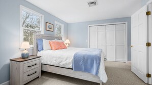 A bedroom with a bed, bedside tables, a wardrobe, and a window. - Sandy Spot: Walk to Beach, Sleeps 10 (Harwich Port)