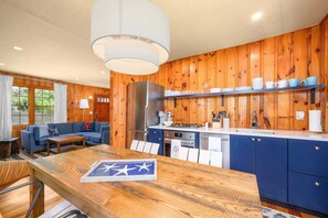 Una cucina compatta con rivestimenti in legno, un frigorifero, un piano cottura e un lavandino.