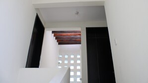 A staircase with white walls and a black door at the bottom. - Casa Blanca Oaxaca (Oaxaca)