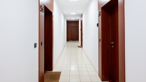 Um corredor com portas numeradas 54 e 56, dando acesso a quartos.