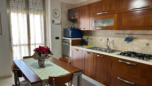 A kitchen with wooden cabinets, a gas stove, a microwave, and a sink. - Spacious, centrally located home, very close to the subway (Napoli)