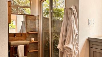 Une salle de bain avec des toilettes, un lavabo et une grande fenêtre.
