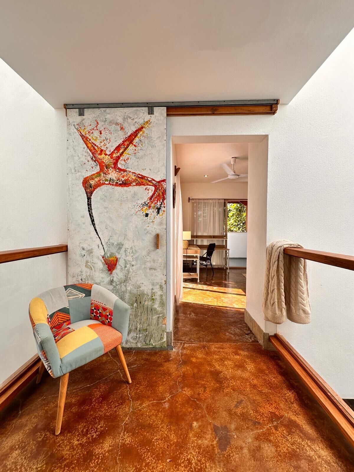 Un interior moderno con un mural único en la pared, una zona de estar acogedora y vistas a un comedor.