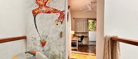 Un interior moderno con un mural único en la pared, una zona de estar acogedora y vistas a un comedor.