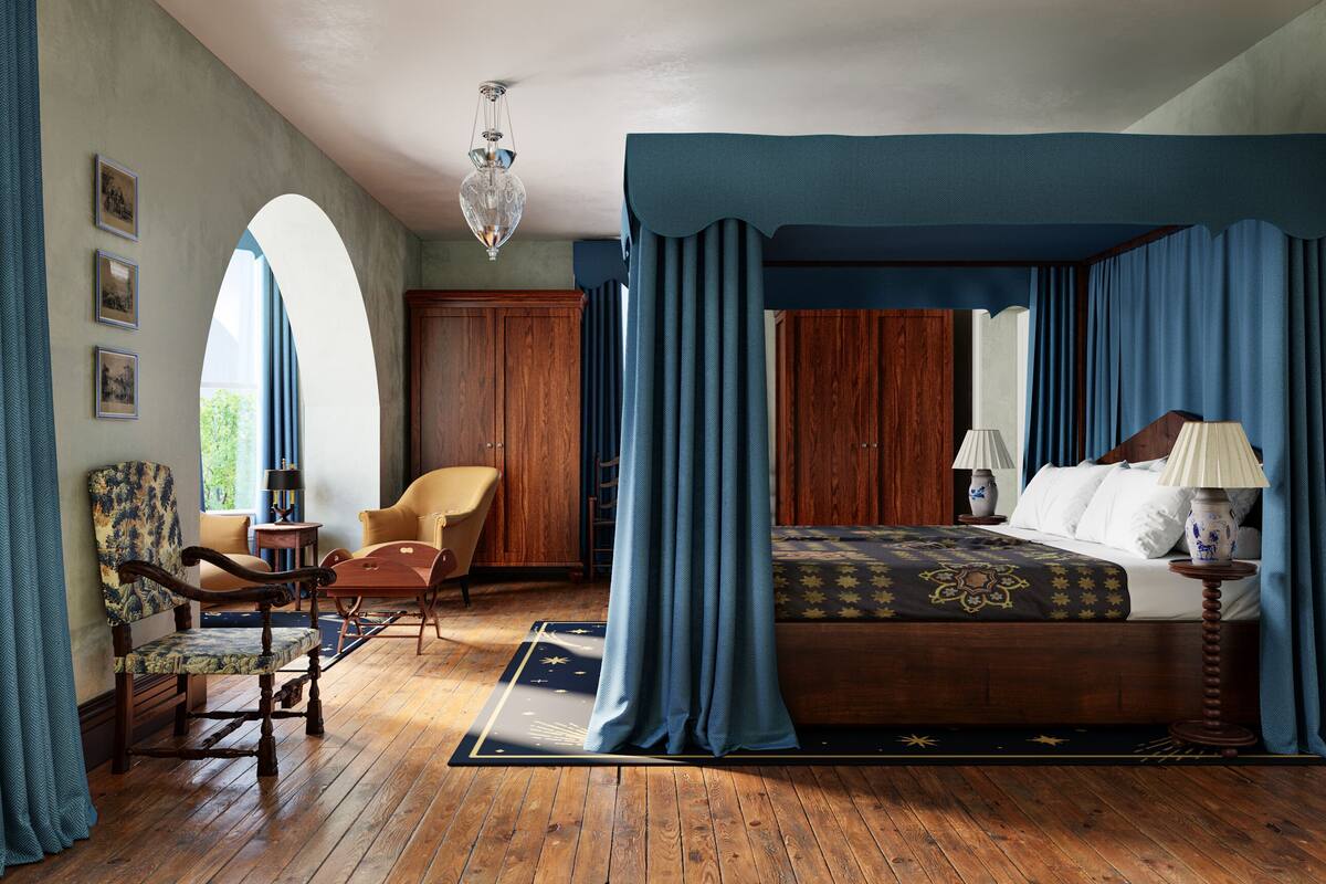 A bedroom with a four-poster bed, wooden flooring, a chandelier, and a view of the outdoors.