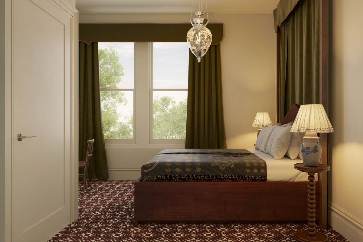 A bedroom with a bed, a nightstand, a lamp, and a window with curtains.