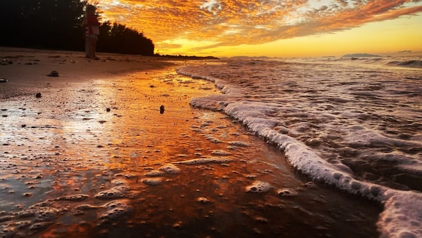 A beach scene with a sunset, waves, and a person standing on the shore. - Balgal Beach Units (Balgal Beach)