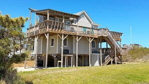 A two-story house with a wooden deck and a staircase leading to the upper level. - Edgewater - Oceanfront with panoramic views! 4 bedroom, 3 baths, dog friendly and spa bath! (Southern Shores)
