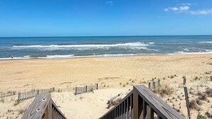 A beach with a wooden boardwalk leading to the water, a sandy beach, and the ocean. - Edgewater - Oceanfront with panoramic views! 4 bedroom, 3 baths, dog friendly and spa bath! (Southern Shores)