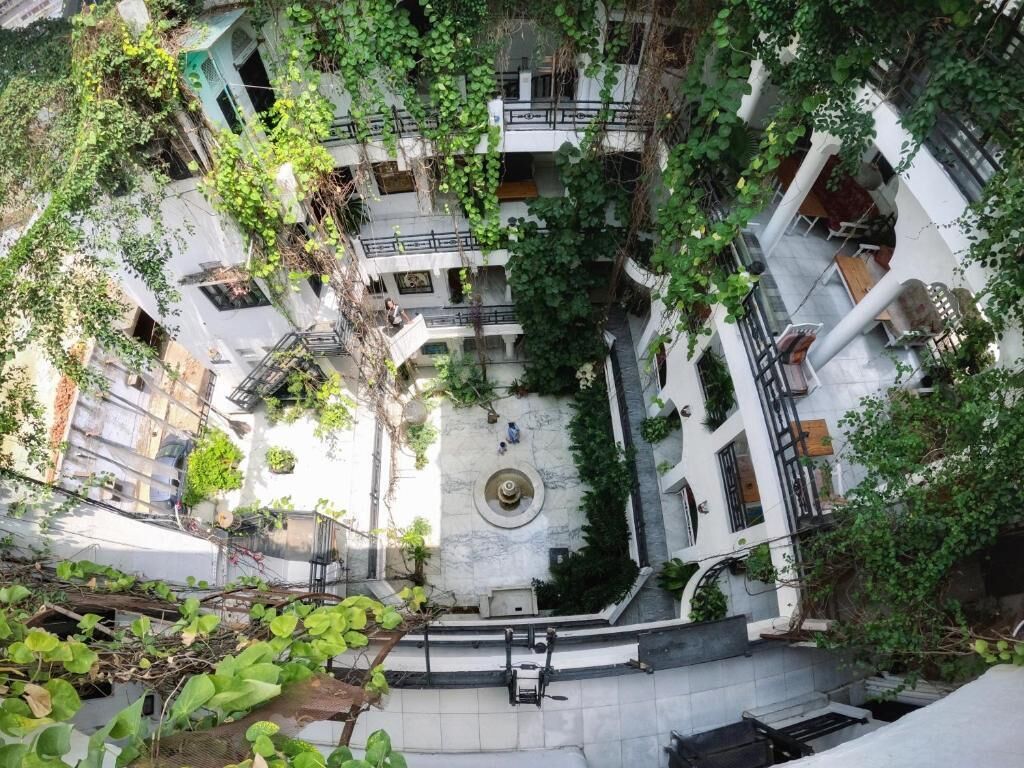 A multi-level courtyard with a central fountain, surrounded by balconies and greenery.