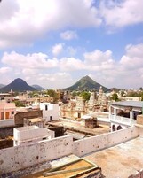 Paesaggio urbano con architettura tradizionale, tra cui templi e edifici residenziali, sotto un cielo sereno.