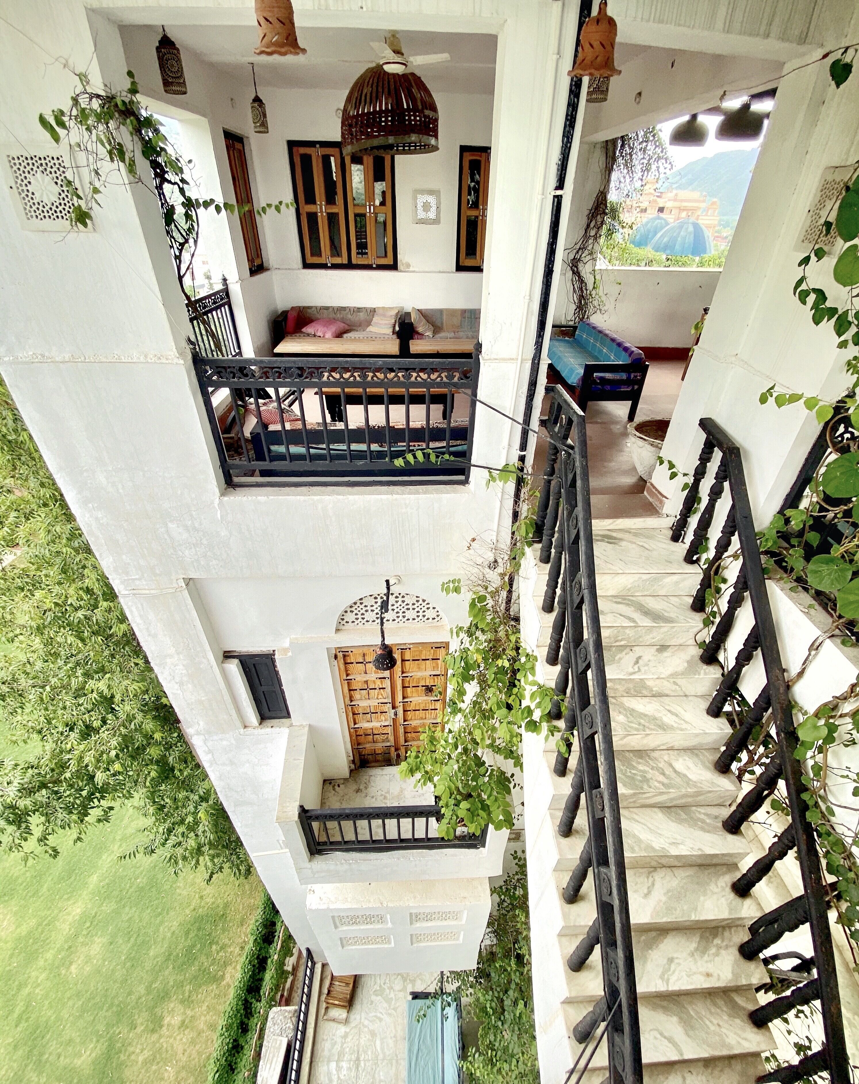 Un edificio de varios pisos con un balcón, una puerta de madera y una escalera.