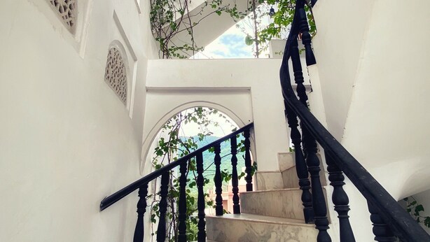 A marble staircase with black balusters leading to a second-floor landing. - Dia homestay (Pushkar)