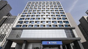 Um edifício moderno de arranha-céu com a placa K-Tree na entrada.