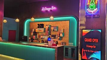 Zona de bar con un letrero de neón, una barra y una exhibición para un evento de inauguración.