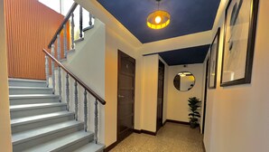 Una escalera con barandilla de madera y un accesorio de iluminación en la parte superior.