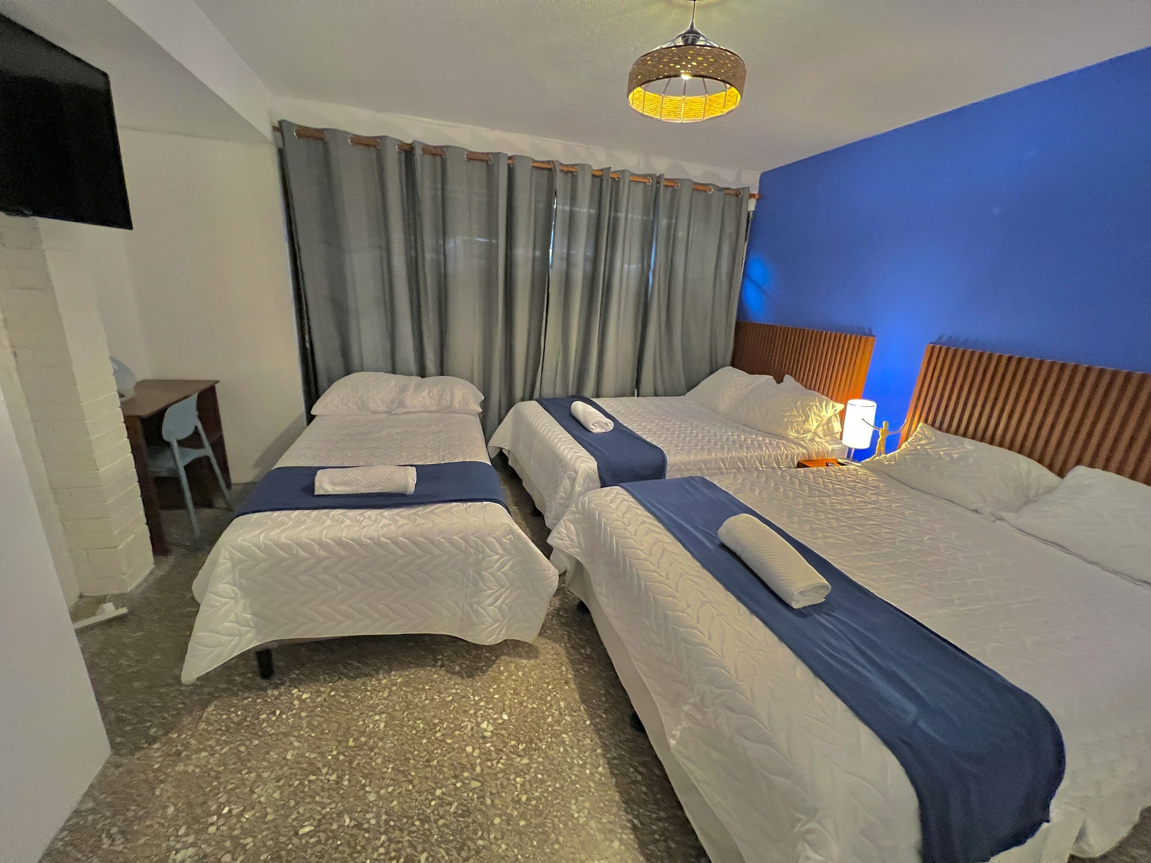 Egy szállodai szoba két ággyal, íróasztallal és egy székkel.