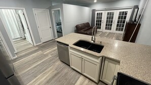 A modern kitchen with a granite countertop, stainless steel appliances, and a walk-in pantry.
