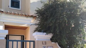 Un edificio con fachada color crema, una reja verde y un letrero con el número 13.
