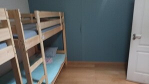A room with a bunk bed, a door, and a wooden floor. - Room-bed 17 in a 6-bed Mixed Dormitory r (Sintra)
