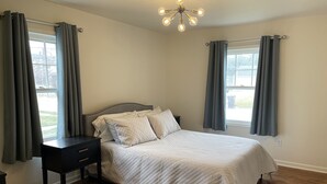 Une chambre à coucher avec un lit, une table de chevet et une commode.