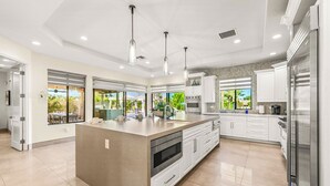 A modern kitchen with a central island, white cabinetry, stainless steel appliances, and pendant lighting. - Luxury+deals,Cinema,Basketball,Volleyball, Pickleball, Putting Green,Ping Ping (Bermuda Dunes)