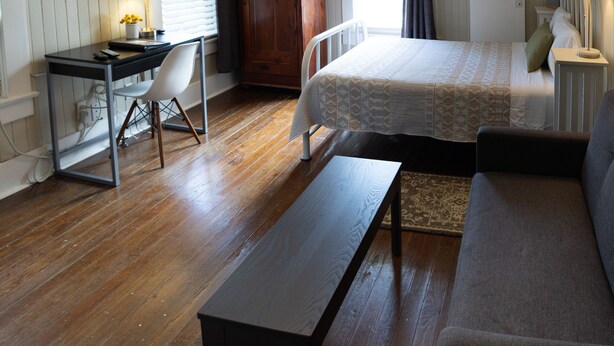 A room with a bed, a desk, a television, and a wardrobe. - Pool Cottage in Historic Old Town Beaumont (Beaumont)