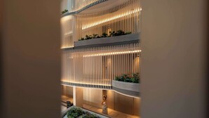 Un edificio moderno con luminarias verticales y zonas verdes en los balcones.